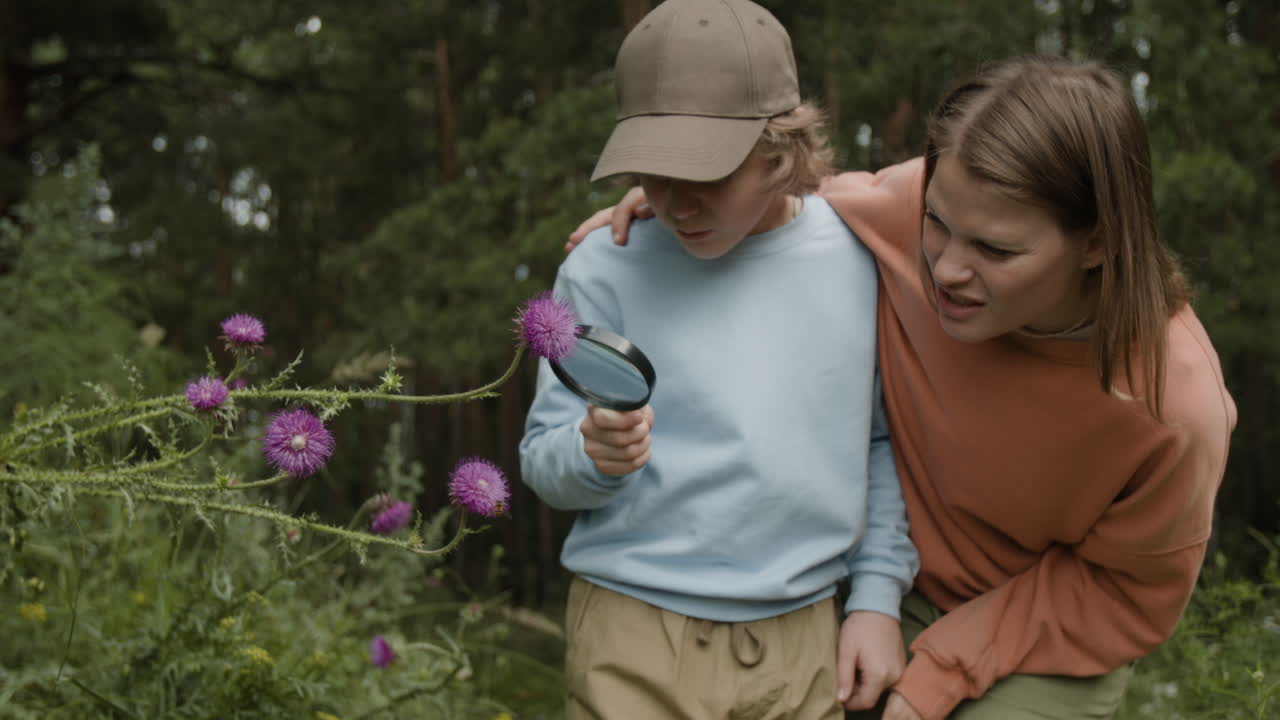 Mother and son exploring nature with a magnifying glass