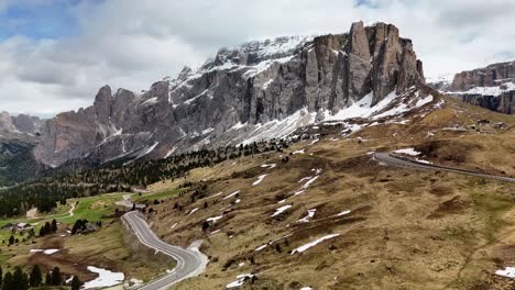 This aerial 4K footage captures the beauty of late-season snow against rugged mountain cliffs, weaving roads, and the serene atmosphere of the Italian Alps. Sella Pass scenic drive