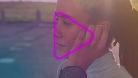 icono de juego púrpura de neón contra el primer plano de una mujer afroamericana con auriculares