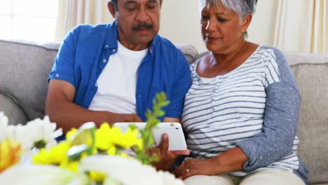 Senior-couple-using-digital-tablet-in-living-room-4k