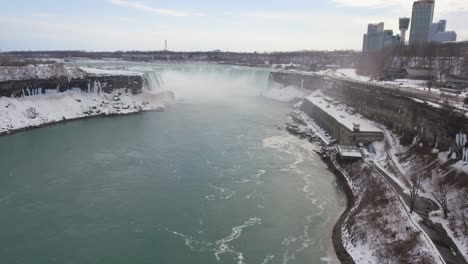 horseshoe falls at niagara falls in snowy winter, wide aerial push-in