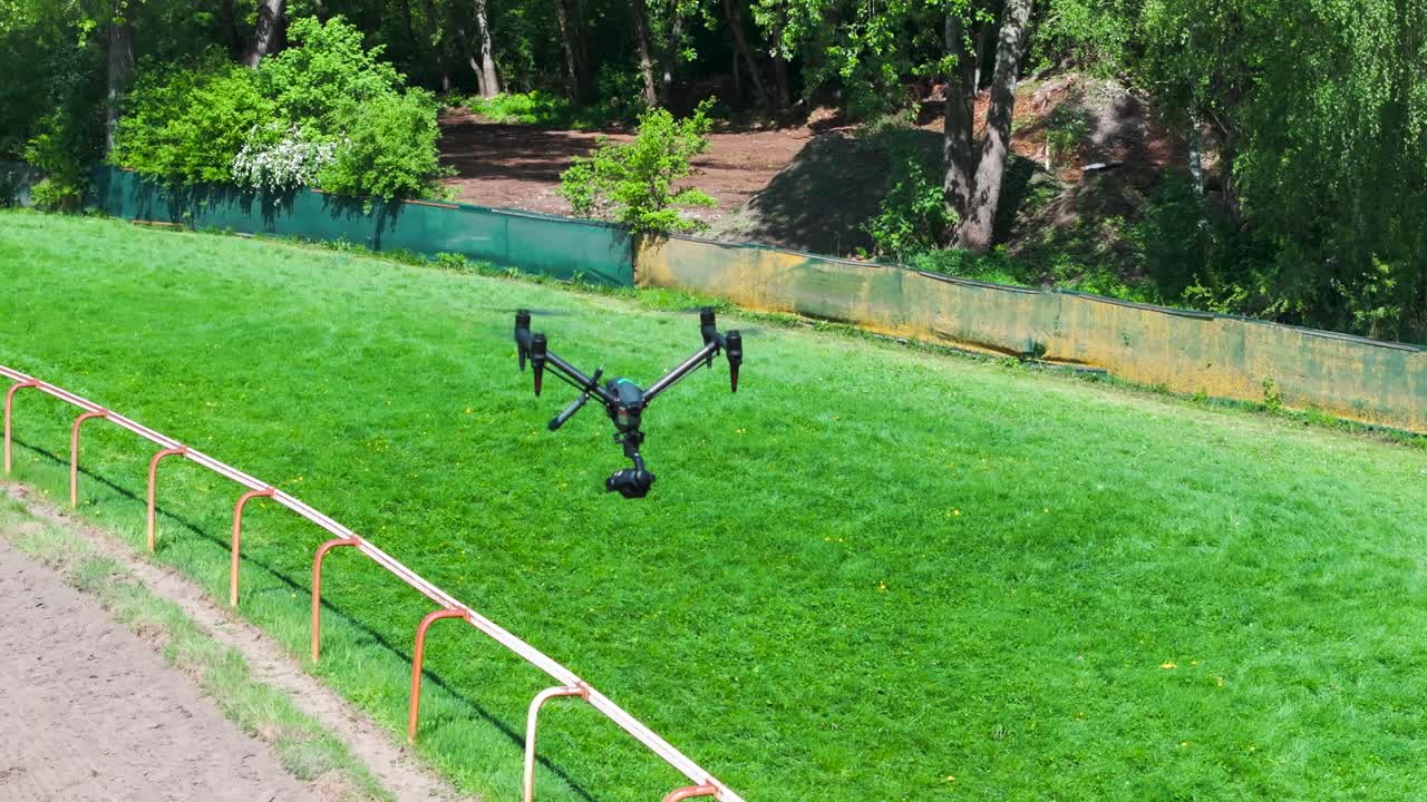 Transformable movie production drone hover above green grass field, Czechia