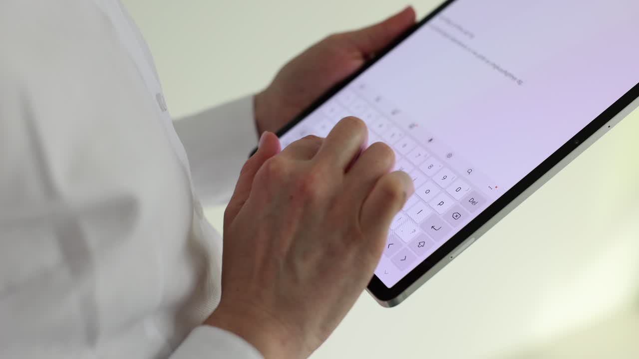 Hands typing on a tablet