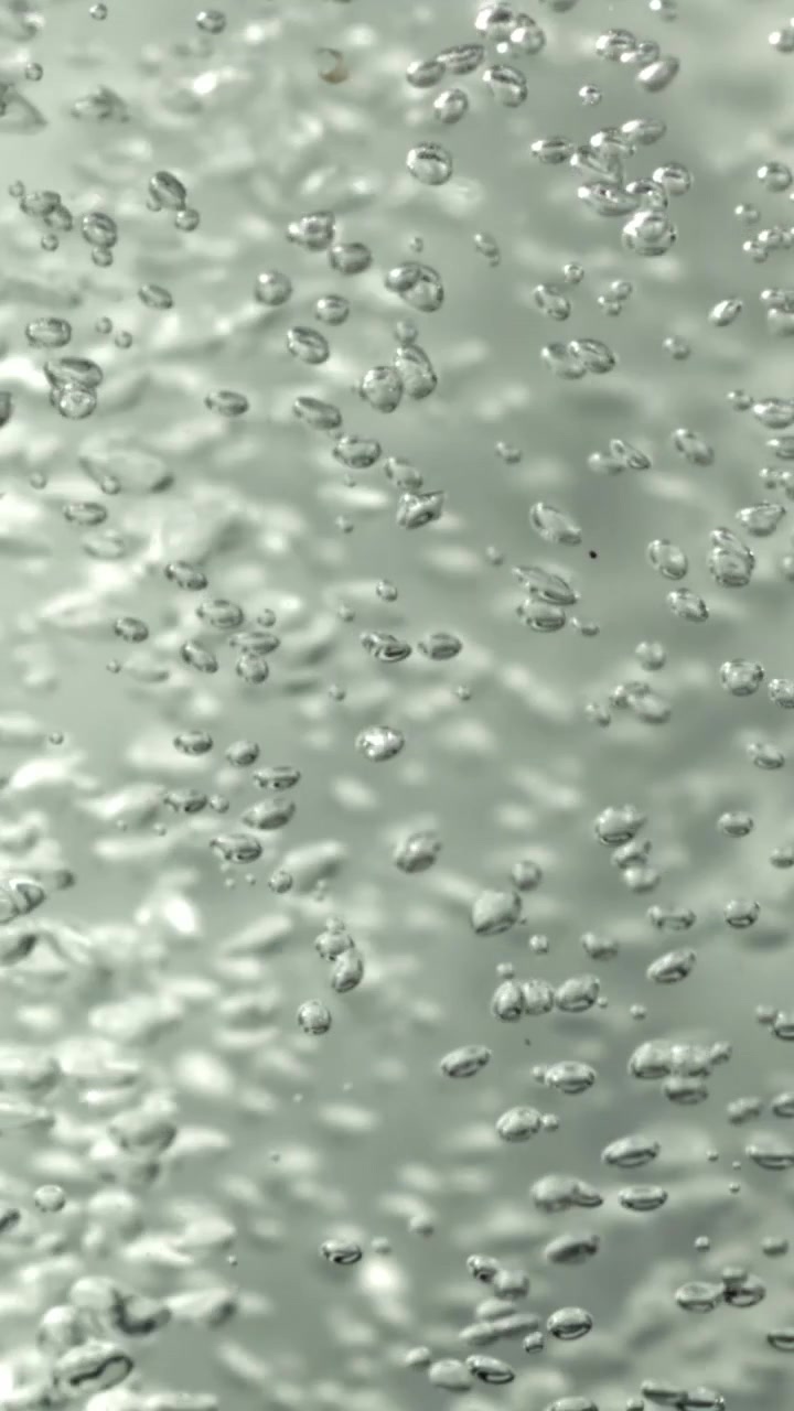 Bolle d'aria effervescenti che salgono in acqua limpida