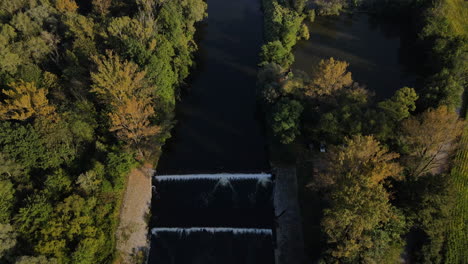 Fliegen-Sie-über-Den-Fluss,-Umgeben-Von-Bäumen-Rund-Um-Den-See-Und-Ein-Paar-Wasserflößen