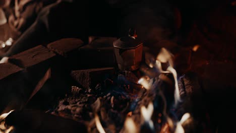 Lagerfeuerkaffee:-Funken-Und-Flammen-Fliegen-Vom-Lagerfeuer,-Während-Eine-Moka-Kanne-Auf-Der-Glut-Steht-Und-Frischen-Kaffee-Kocht