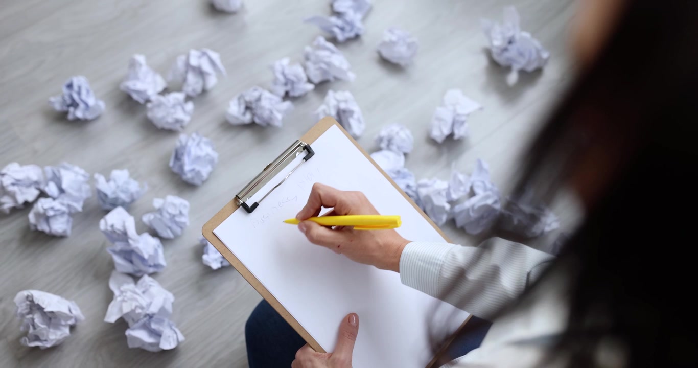 Woman rewrites draft under pressure creating focused struggle