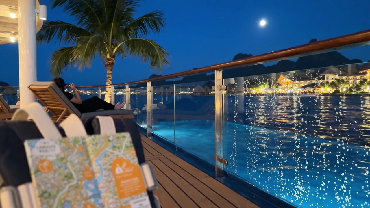 A serene evening by the pool with a scenic map on a backpack, showcasing the beautiful night view and sparkling water reflections in the background.