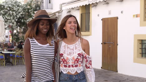 Two-female-friends-walking-in-the-streets-of-Ibiza,-Spain,-shot-on-R3D