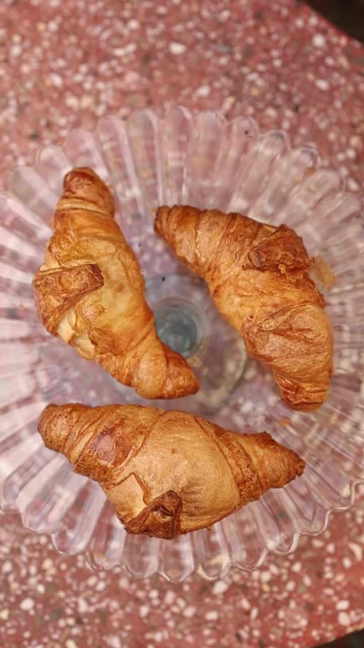 Three Golden Croissants on a Clear Glass Plate
