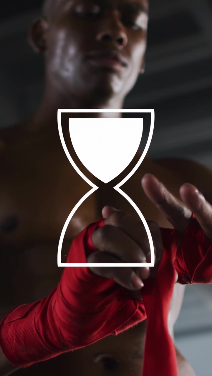 Vertical video: Boxer grabbing red wraps wrapping hands hourglass flipping in time, preparing fight