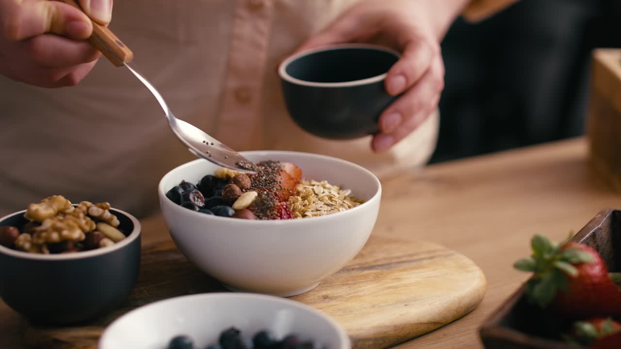 Donna che aggiunge semi a una ciotola di muesli.