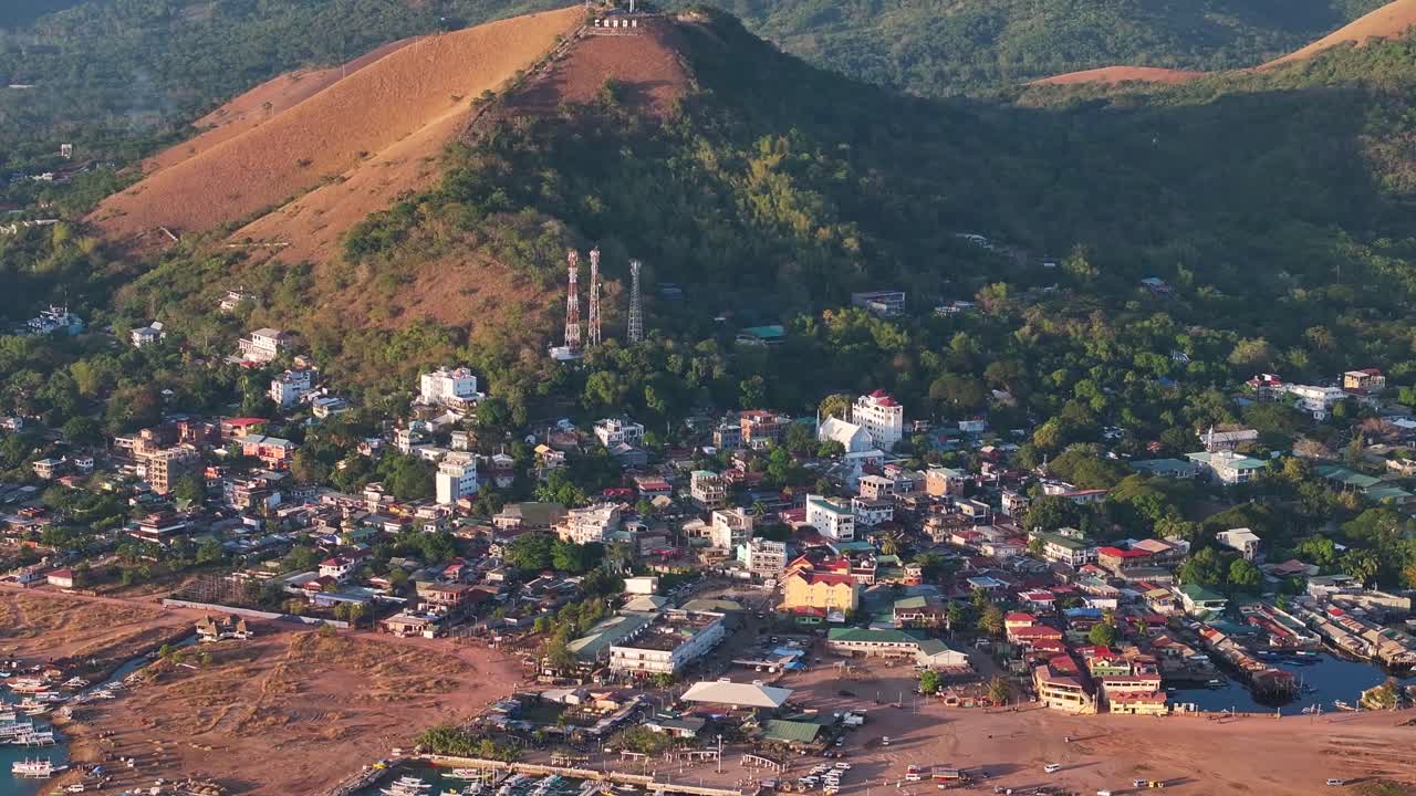 Coron town in Busuanga Island with buildings, hill top and scenic view covered in warm light.