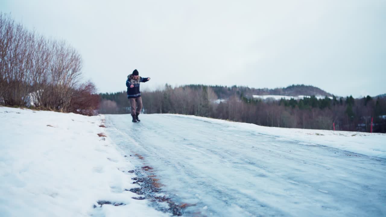 한 남자가 미끄럽고 얼어붙은 도로를 으려고 합니다.