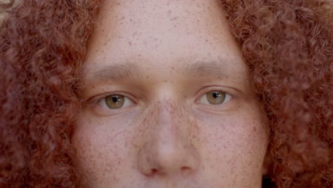 retrato de un hombre caucásico con cabello rojo y pecas sonriendo, en cámara lenta