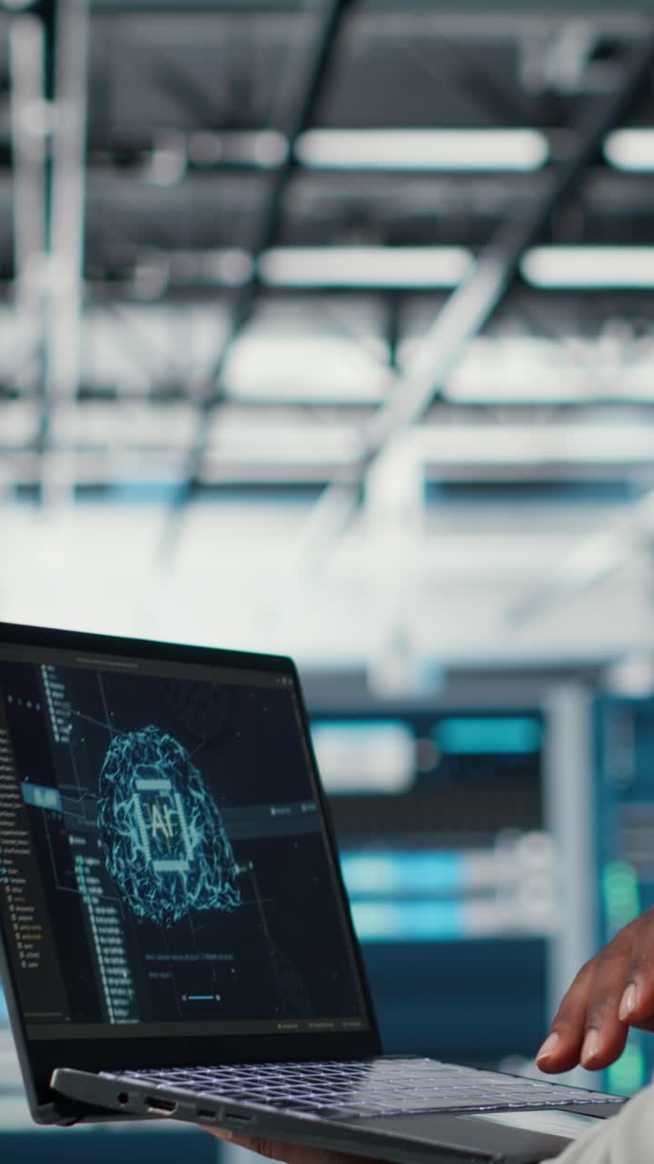 Vertical video Software developer in data center uses AI technology on laptop