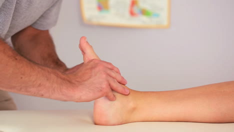fisioterapeuta que trabaja en el pie de un paciente