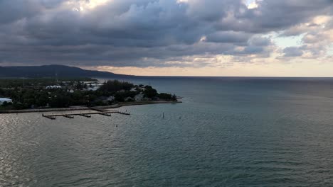 time lapse view departing kingston, jamaica by boat under a cloudy sky at sunset