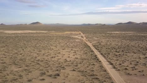 a lonely person stands all alone on a deserted road in the desert