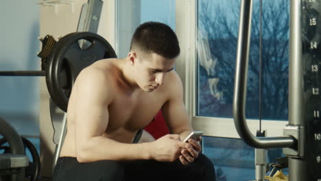 man using phone in gym