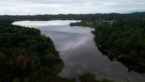 mire hacia el oeste a través del agua de cristal en el pequeño lago negro antes de una tormenta