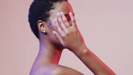 african american woman with short dark hair in blue and pink light with copy space, slow motion