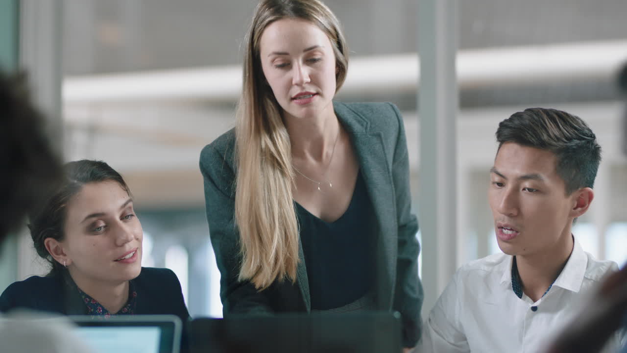 uomini d'affari che fanno brainstorming usando un computer portatile team leader donna che punta allo schermo condividendo idee creative aiutando i colleghi a discutere di progetti lavoro di squadra in un ufficio moderno 4k