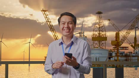 businessman at an oil rig with wind turbines