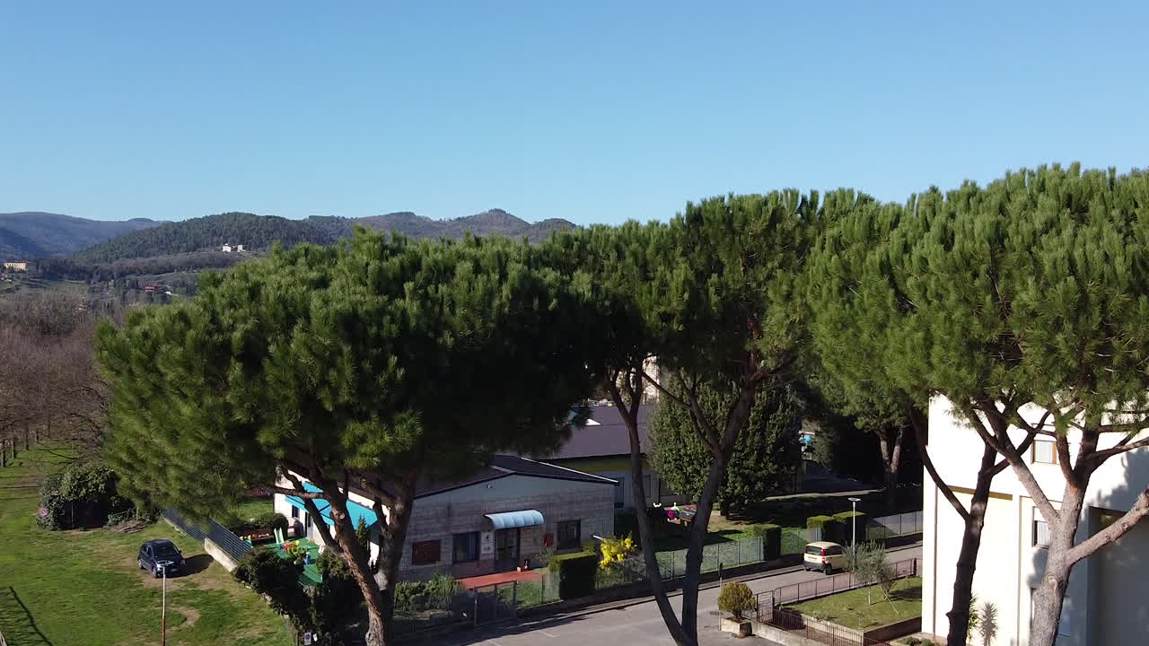 Reverse Riverside flying through trees in Sunset drone above the Arno river. Sieci small town near Pontassieve Florence, in the Tuscany region of Italy. December 2019