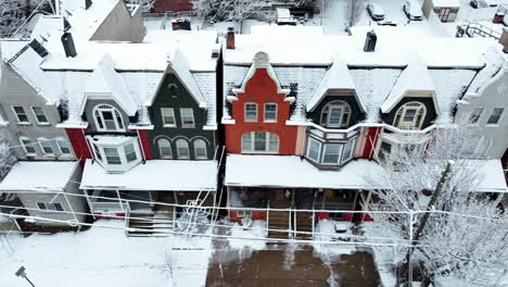 truck shot of colorful old victorian homes in winter snow