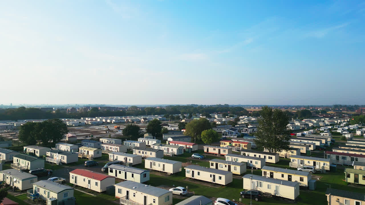 Experience Skegness's holiday parks through this aerial view, showcasing caravans, holiday homes, and the scenic countryside on a summer evening
