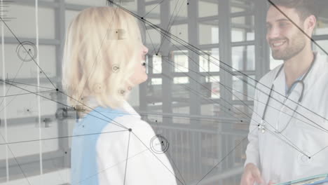 doctor and nurse holding clipboard and stethoscope in corridor, showing network graphic overlay