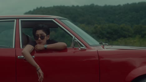 person in vintage red car