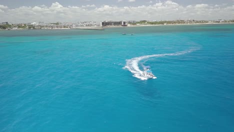 Antena---Barco-De-Lujo-A-Toda-Velocidad-A-Través-De-Aguas-Azules,-Cancún,-México,-Tiro-Giratorio