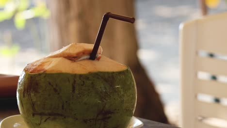 a coconut with a straw on a sunny day