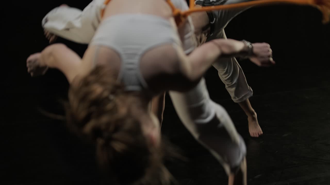 luchadores de capoeira realizando movimientos dinámicos en el escenario. artes marciales, danza y acrobacias en acción. atletas de pecho desnudo mostrando fuerza, flexibilidad y técnica bajo los reflectores