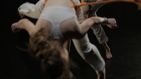 capoeira fighters performing dynamic moves on stage. martial arts, dance, and acrobatics in action. bare-chested athletes showcasing strength, flexibility, and technique under spotlights