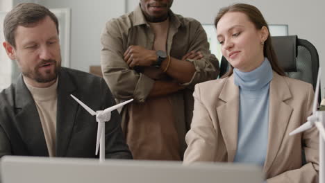 portret van een multi-etnisch zakelijk team dat op kantoor discussieert over windenergieprojecten