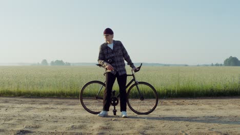 man on fixed gear bicycle in a field at sunrise