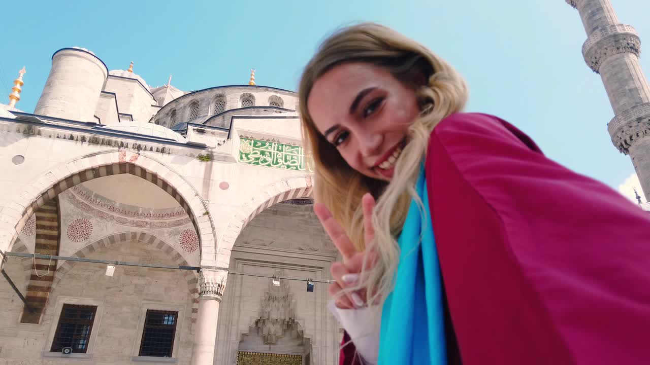 garota bonita e atraente de camisa tira selfie com vista para a mesquita do sultão ahmet em istambul, turquia