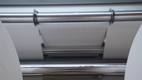 huge rolls of paper on rolling slitter for custom cutting in a printing factory