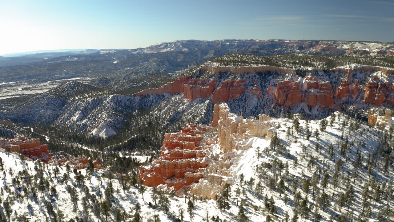 Stunning winter landscape of a snow-covered canyon with red rock formations and evergreen trees