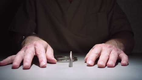 close-up shot that slowly dollies in on a prisoner's hands, cuffed to a table in an interrogation room