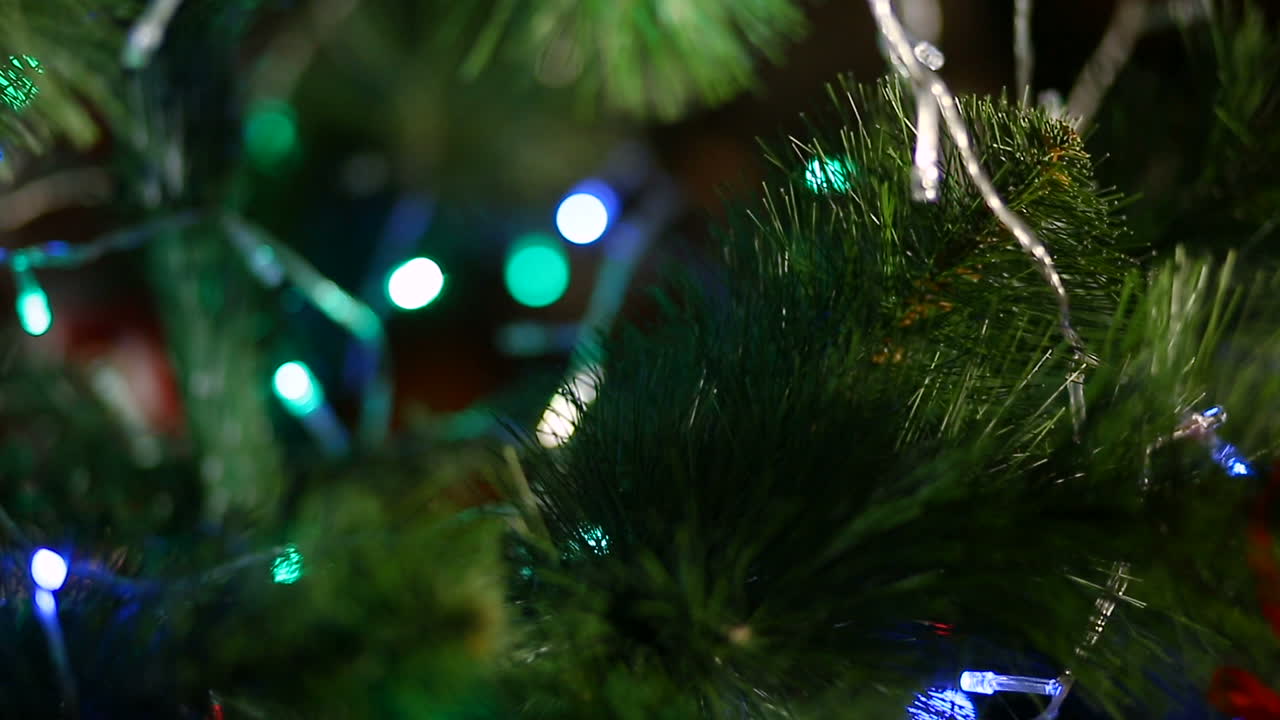 Kid Decorate Christmas Tree. Smiling little boy decorates Christmas tree in house