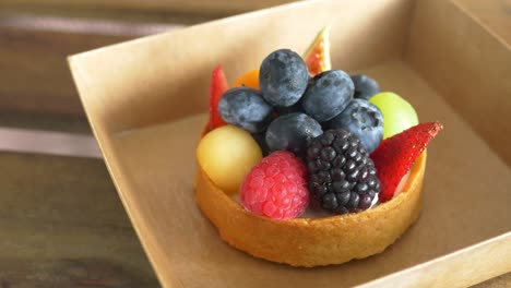 close up of berry fruit tart in a paper packet ,