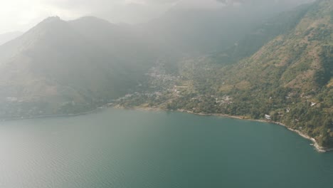 drone aerial view during sunny day of san marcos la laguna, lake atitlan, guatemala