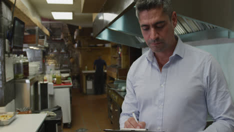 Caucasian-man-writing-in-the-kitchen