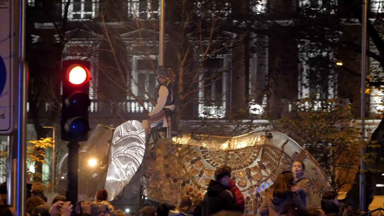 A close-up of a mechanical elephant float at the Three Kings Parade (Cabalgata de Reyes) with a masked pirate-like figure, surrounded by festive crowds and historic buildings in the background.