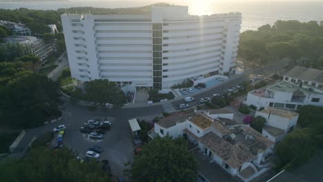 aerial-orbit-over-on-hotel-buildings-in-front-to-the-sea-surrounded-by-rainforest,-riviera-maya,-quintana-roo,-mexico