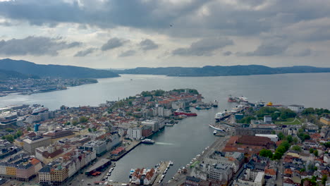 beautiful drone shot from bergen, norway with moving clouds, boats, traffic and rays of sun peaking through the clouds